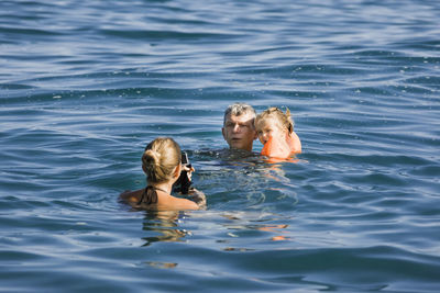 High angle view of family swimming in sea