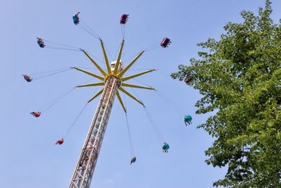 Low angle view of chain swing ride against clear sky