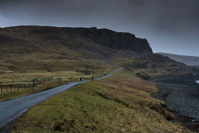 Road leading towards mountains against sky