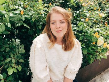 Portrait of young woman by plants