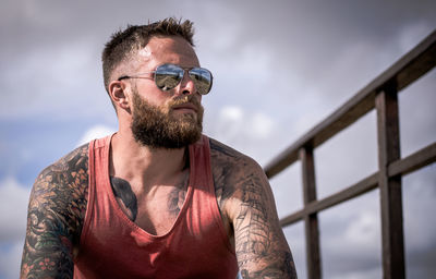 Man wearing sunglasses standing against sky