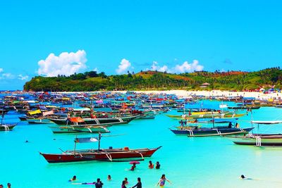 Boats moored in swimming pool against blue sky