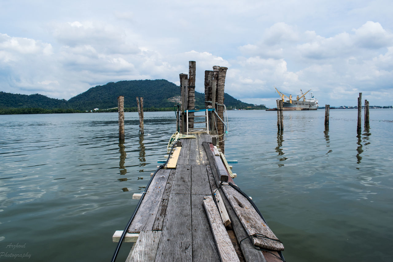 WOODEN POSTS ON JETTY AGAINST SKY