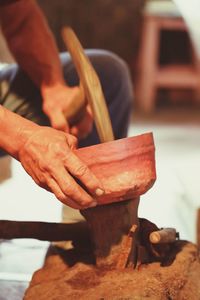 Midsection of man making clay pots