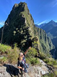 Woman standing on mountain against blue sky