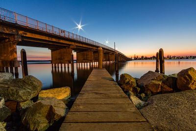 Pier over river against clear sky