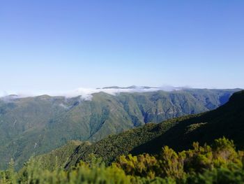 Scenic view of mountains against clear blue sky