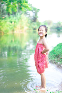 Young woman smiling while standing in lake