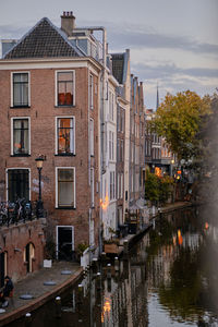 Tall canal houses and reflections on the oudegracht canal in utrecht city centre. autumn evening.