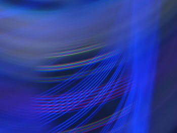 Close-up of light trails over blue background