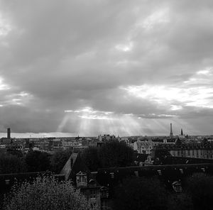 View of cityscape against cloudy sky