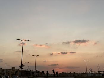 Silhouette street against sky during sunset