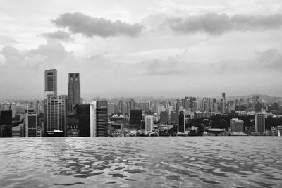 View of cityscape against cloudy sky