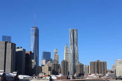 Skyscrapers in city against blue sky