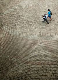 High angle view of men sitting on footpath