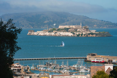 High angle view of city by sea against sky