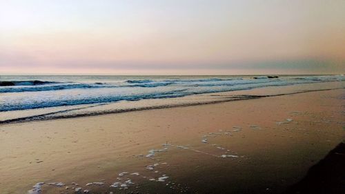 Scenic view of beach against sky during sunset