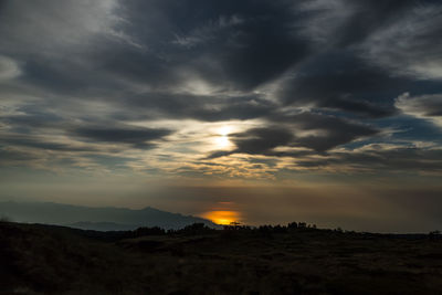 Scenic view of dramatic sky over silhouette landscape