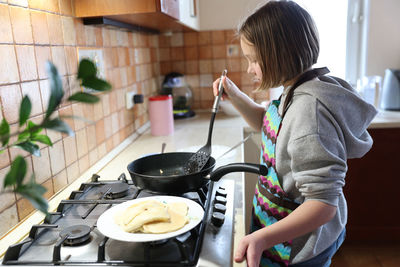 Side view of woman having food at home