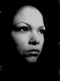 Portrait of young woman over black background