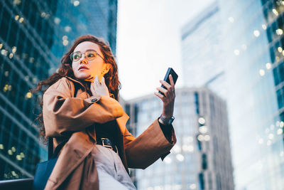 Young woman using mobile phone in city