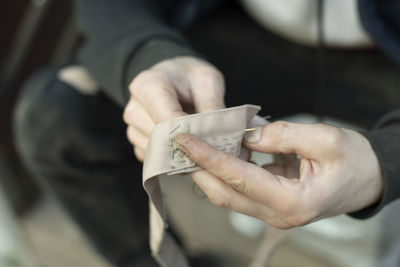 Midsection of man holding paper currency