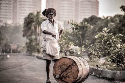 Portrait of man with drum standing on street