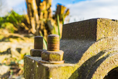 Close-up of rusty metal stack against sky