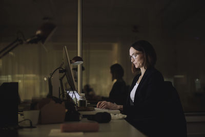 Businesswoman concentrating while working on laptop in office at night