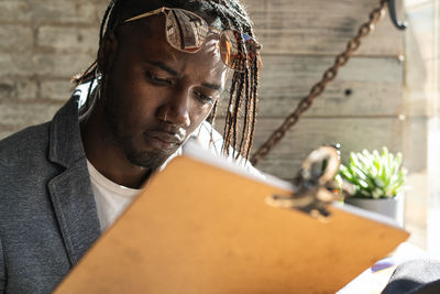 Close-up of serious young man reading menu in cafe