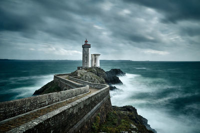 Phare du petit minou by sea against cloudy sky