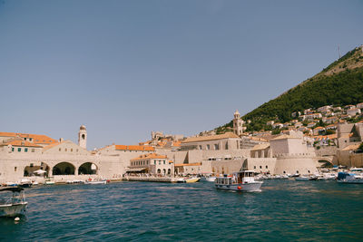 View of buildings by sea against clear sky