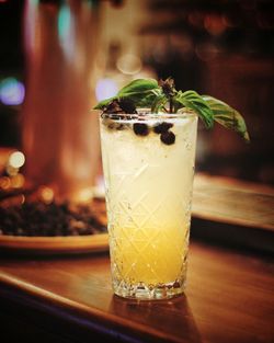 Cocktail with a basil served on a bar desk 