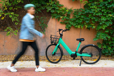 Side view of man cycling bicycle against plants