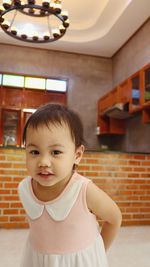 Portrait of cute girl standing at home