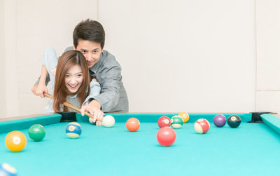 Couple playing pool on table