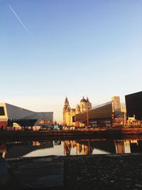River by buildings against clear sky