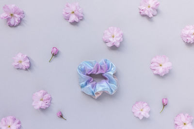 Shiny metallic scrunchie and fresh spring cherry blossom pink flowers