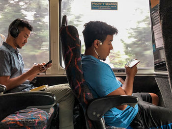 Young woman using mobile phone while sitting on seat