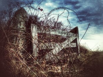 Old building on field against cloudy sky