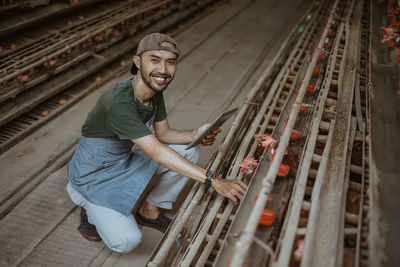 Portrait of young man standing on railroad track