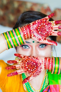 Portrait of mid adult woman with colorful bangles at home
