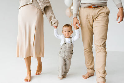 Rear view of couple standing against white background
