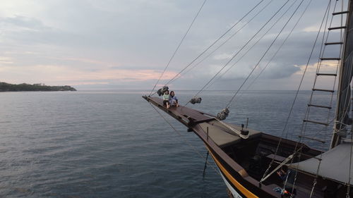 Sailboat sailing on sea against sky during sunset