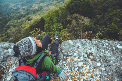 High angle view of woman sitting at cliff 