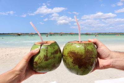 Romantic moment with coconuts and straws on lagos do paraiso, jericoacoara, brazil