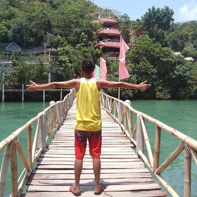 water, full length, rear view, lifestyles, railing, leisure activity, casual clothing, standing, pier, built structure, river, architecture, lake, tree, footbridge, person, wood - material, nature