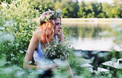 Young woman with plants in lake