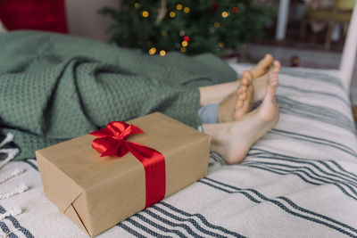 Midsection of woman relaxing on bed at home