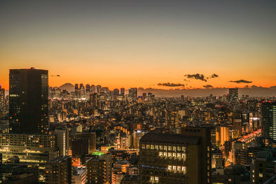 High angle view of illuminated cityscape against sky during sunset